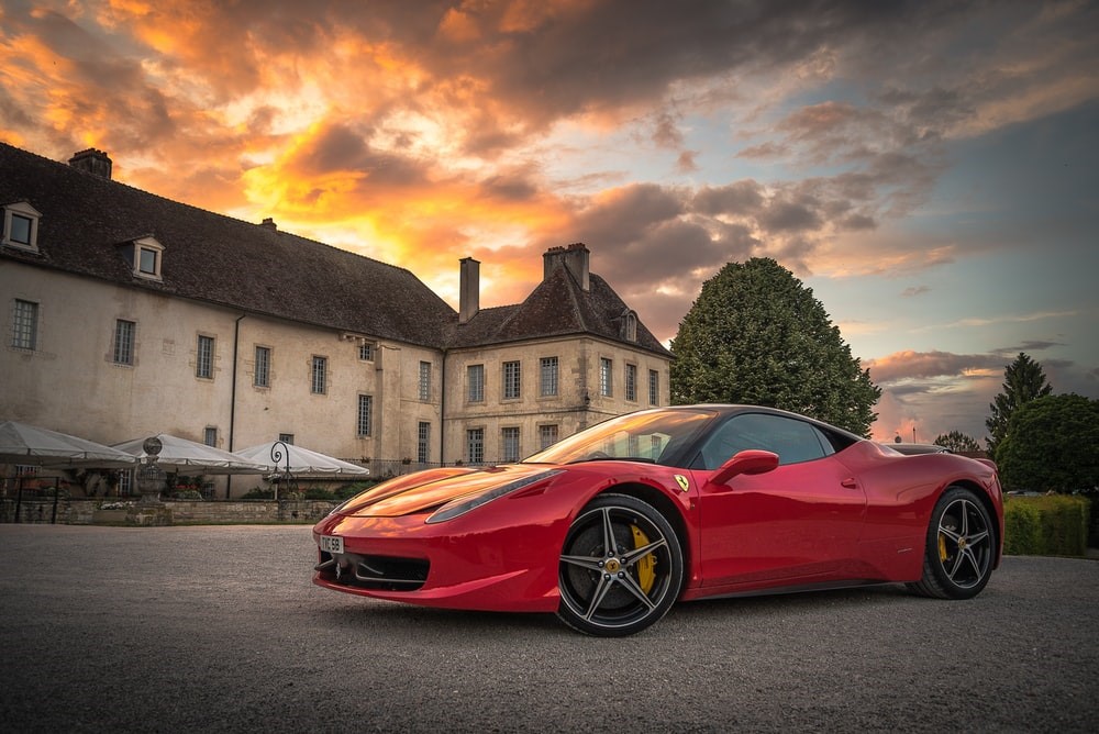 A red Ferrari parked near a building