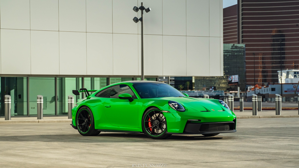 A green luxury car in the parking lot