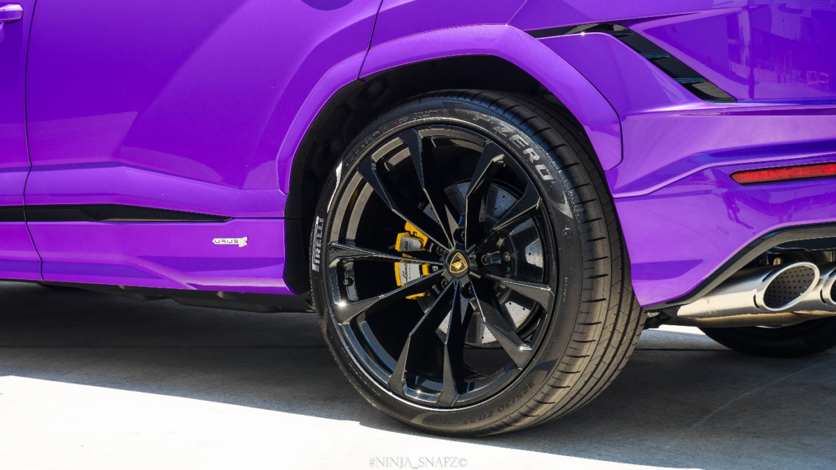 A close-up of a purple car’s wheel.