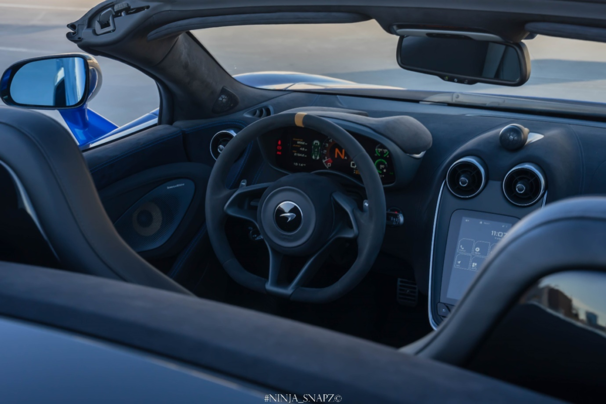 The interior of a McLaren 600LT in Spider Blue color is being shown.