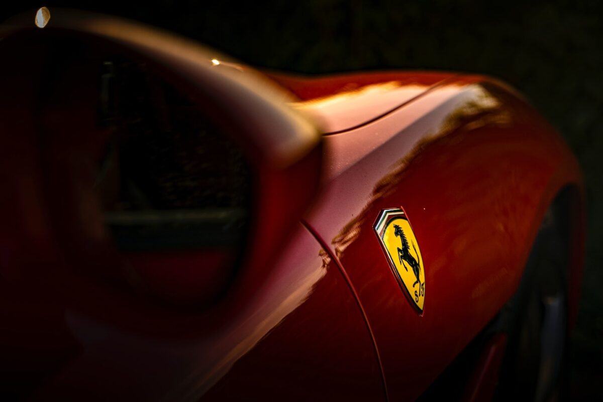 Selective focus on a logo of a red Ferrari